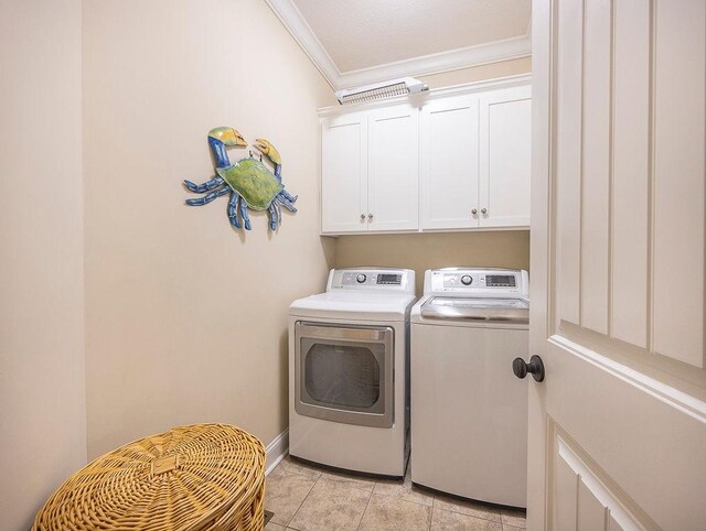 laundry area with crown molding, washer and clothes dryer, light tile patterned flooring, and cabinets