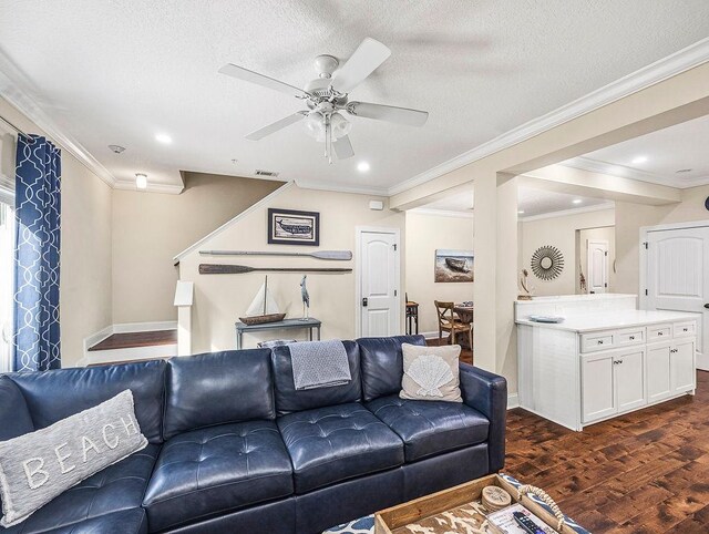 living room featuring ornamental molding, a textured ceiling, ceiling fan, and dark wood-type flooring