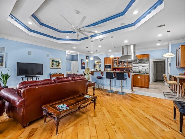 bedroom featuring carpet flooring, visible vents, baseboards, a raised ceiling, and crown molding