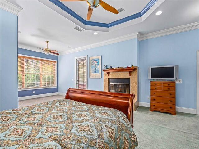 interior space with light carpet, ornamental molding, a fireplace with raised hearth, and a walk in closet