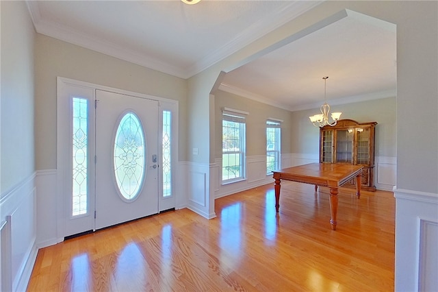 6121 Stoney Brook Dr, Blackshear, GA 31516 - entrance foyer featuring an inviting chandelier, arched walkways, ornamental molding, wainscoting, and light wood-type flooring