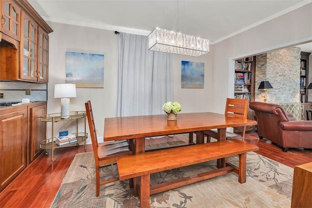407 Butler Ave, Saint Simons Island, GA 31522 - dining space with wood finished floors, a chandelier, and crown molding