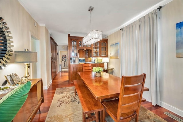 407 Butler Ave, Saint Simons Island, GA 31522 - dining space with a chandelier, dark wood-style floors, and baseboards