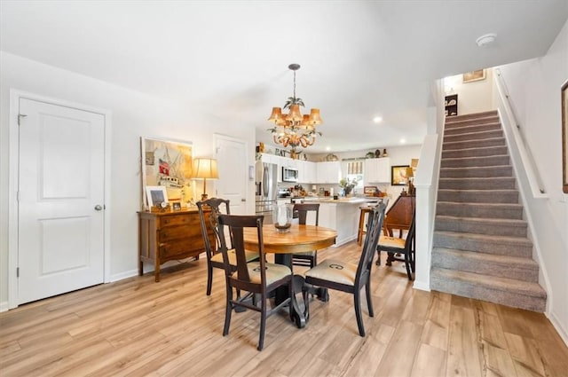 102 Cathead Ln, Darien, GA 31305 - dining room with a notable chandelier, light wood-type flooring, stairway, baseboards, and recessed lighting