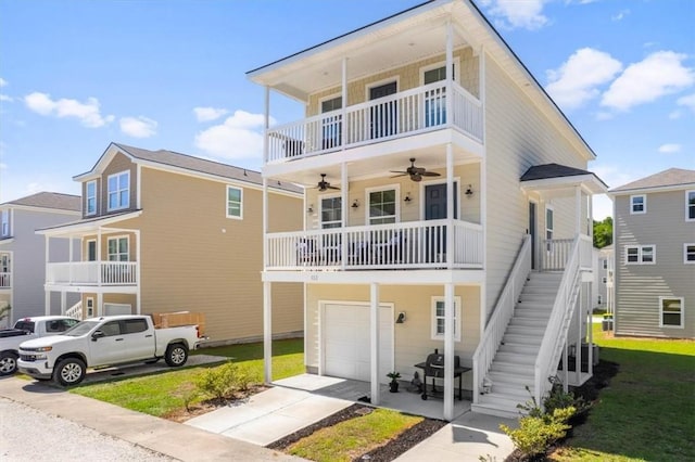 102 Cathead Ln, Darien, GA 31305 - view of front of house with a ceiling fan, an attached garage, concrete driveway, stairway, and a front lawn