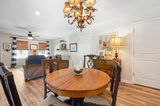 102 Cathead Ln, Darien, GA 31305 - dining room with ceiling fan with notable chandelier, light wood-type flooring, and baseboards
