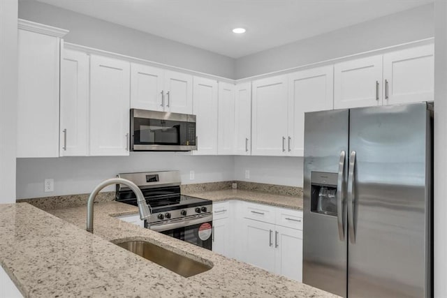1329 New Castle St, Savannah, GA 31415 - kitchen with stainless steel appliances, light stone counters, white cabinetry, and recessed lighting