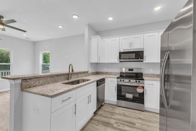 1329 New Castle St, Savannah, GA 31415 - kitchen featuring stainless steel appliances, a sink, a peninsula, a ceiling fan, and white cabinets