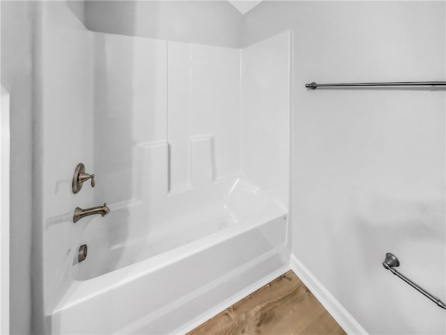 bathroom featuring hardwood / wood-style flooring and  shower combination