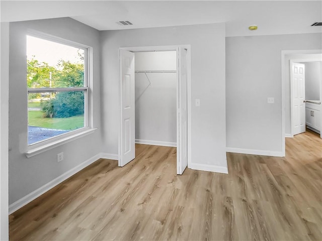 unfurnished bedroom featuring light hardwood / wood-style floors and a closet