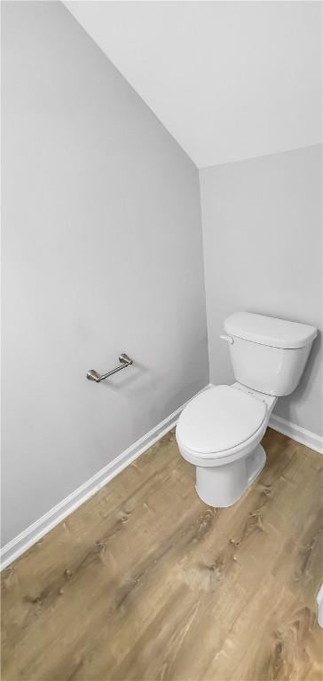 bathroom with lofted ceiling, wood-type flooring, and toilet