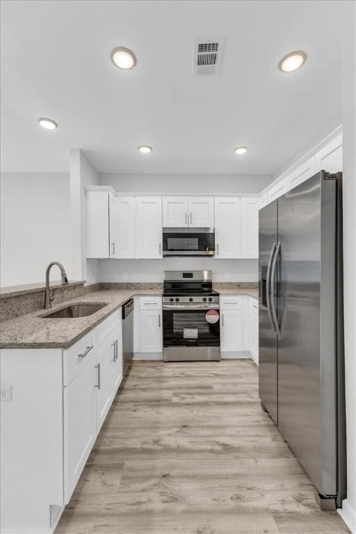 1329 New Castle St, Savannah, GA 31415 - kitchen featuring appliances with stainless steel finishes, a sink, light stone counters, white cabinets, and recessed lighting