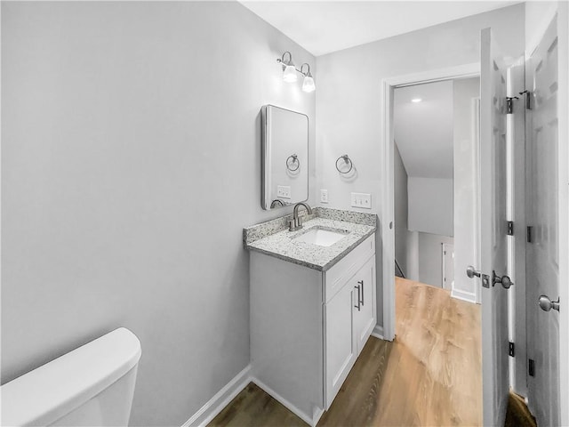 bathroom featuring hardwood / wood-style flooring, vanity, and toilet