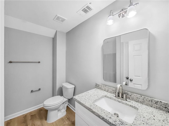 bathroom featuring vanity, toilet, and hardwood / wood-style floors