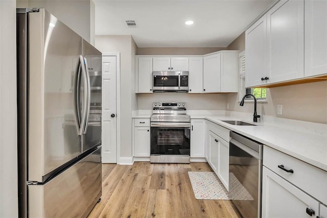 2503 Cleburne St, Brunswick, GA 31520 - kitchen featuring appliances with stainless steel finishes, light wood-style flooring, light countertops, white cabinetry, and recessed lighting