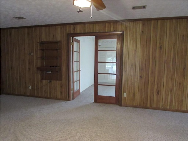 unfurnished room featuring ceiling fan, light colored carpet, and a textured ceiling