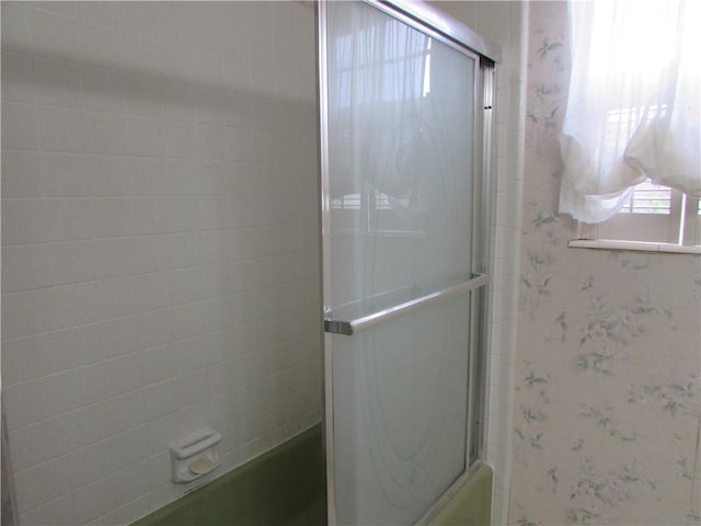 bathroom with combined bath / shower with glass door