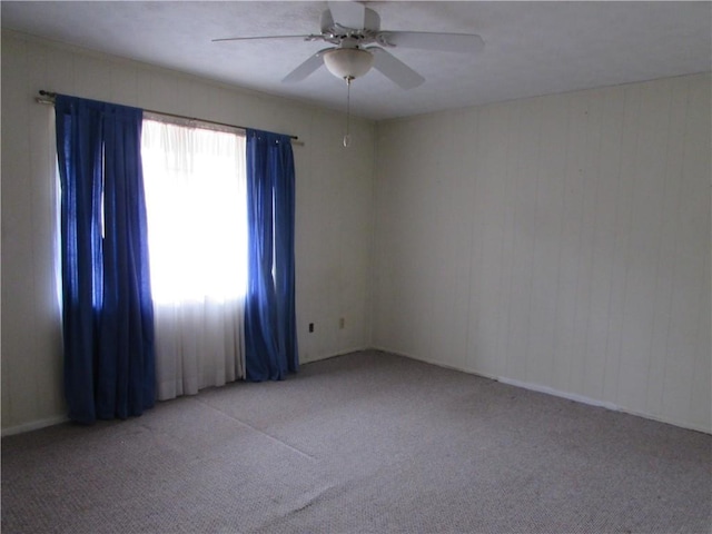 empty room with ceiling fan and light carpet