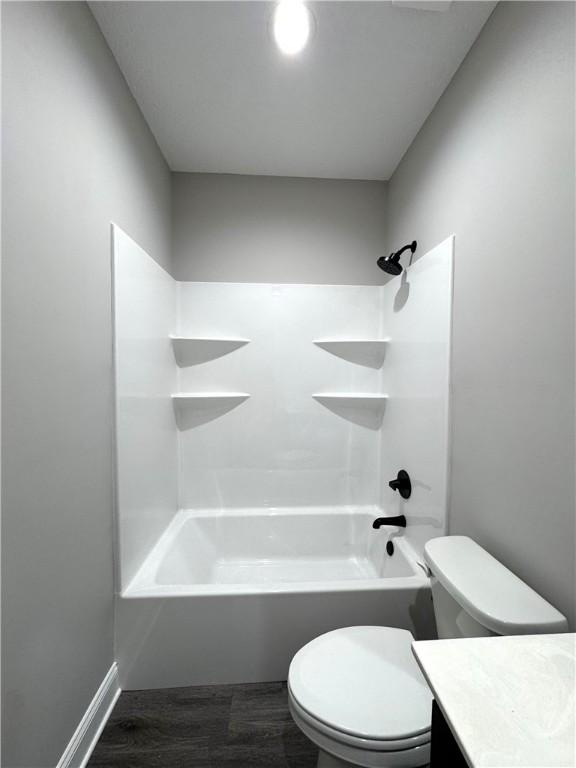 1029 N Church St, Odum, GA 31555 - bathroom with toilet, vanity, wood finished floors, and shower / washtub combination