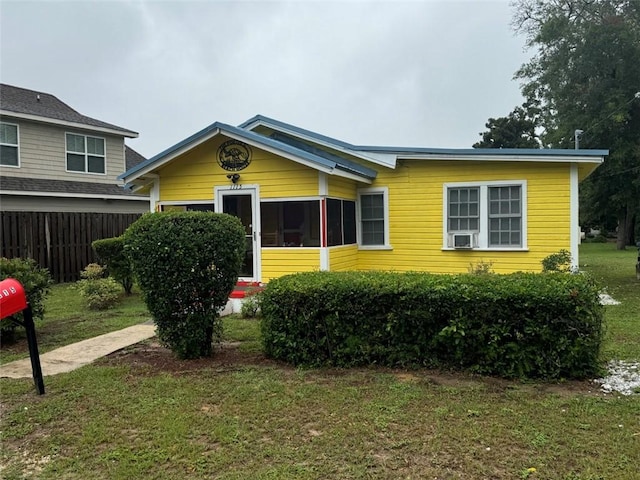 view of front of property with a front lawn and cooling unit