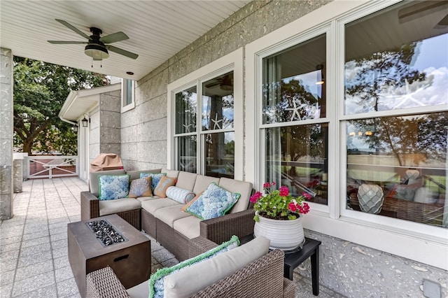 view of patio / terrace with ceiling fan and an outdoor living space with a fire pit