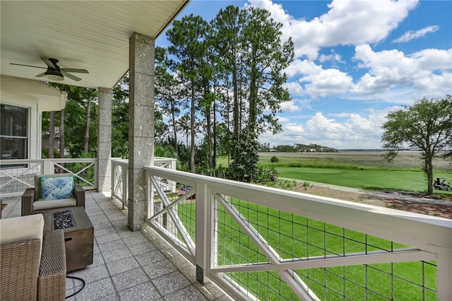 balcony featuring ceiling fan and a fire pit