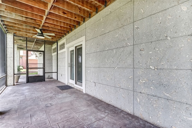 unfurnished sunroom featuring ceiling fan