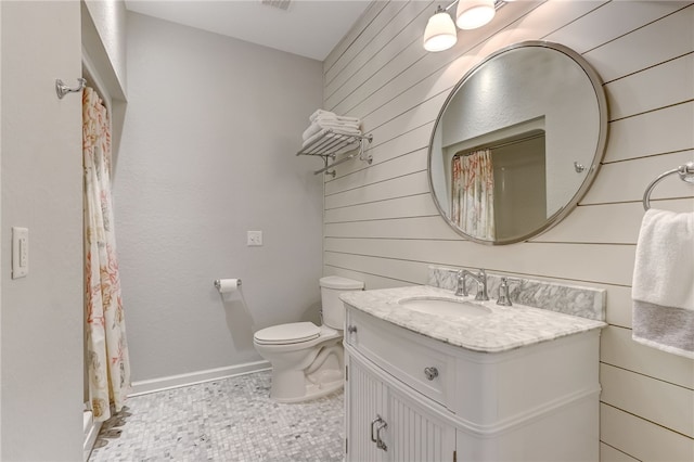 bathroom featuring vanity, wood walls, tile patterned floors, and toilet