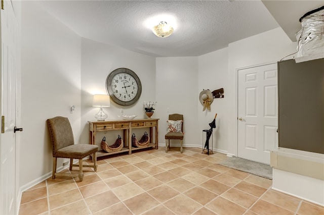 living area with a textured ceiling and light tile patterned floors