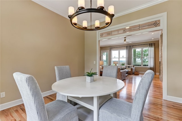 dining area with crown molding, light hardwood / wood-style flooring, and ceiling fan with notable chandelier