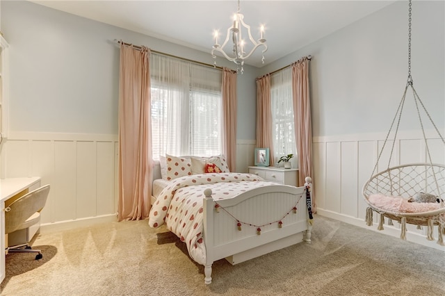 bedroom featuring light colored carpet and a chandelier