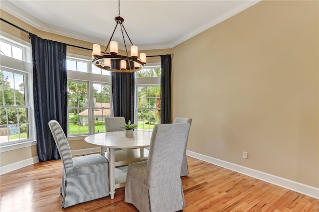 dining area with crown molding, light hardwood / wood-style flooring, and a chandelier