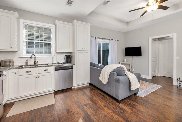 kitchen with decorative backsplash, dark hardwood / wood-style flooring, stainless steel dishwasher, sink, and white cabinetry