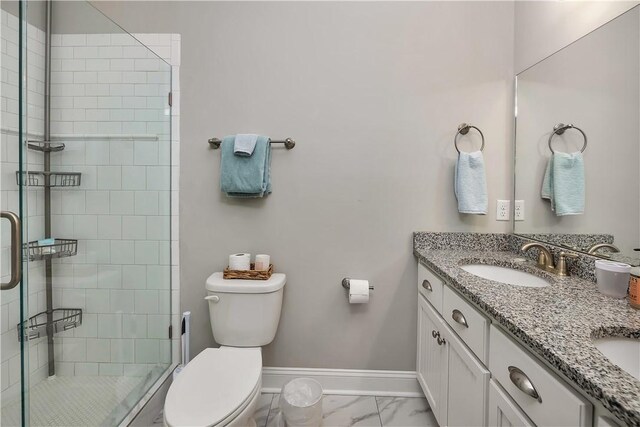 bathroom featuring vanity, toilet, and a shower with shower door