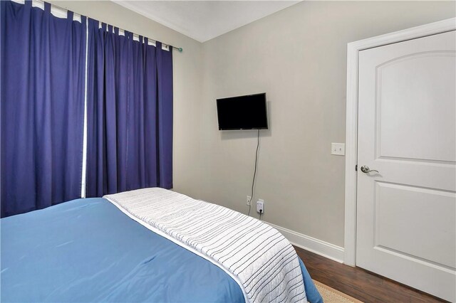 bedroom with dark wood-type flooring