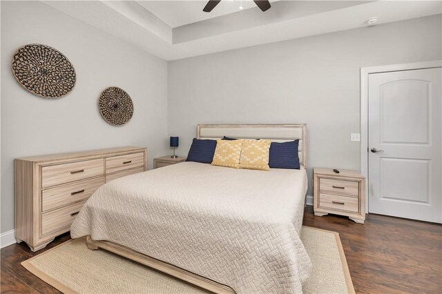 bedroom with dark hardwood / wood-style flooring and ceiling fan