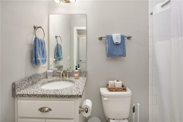 bathroom featuring vanity, a shower with shower curtain, and toilet