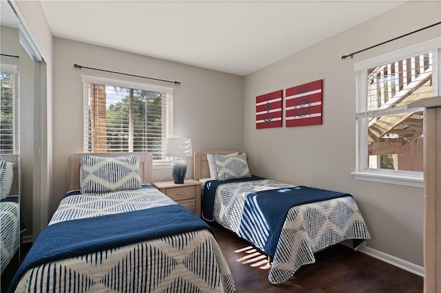 bedroom with multiple windows and dark wood-type flooring