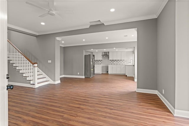 unfurnished living room with ceiling fan, sink, light wood-type flooring, and crown molding