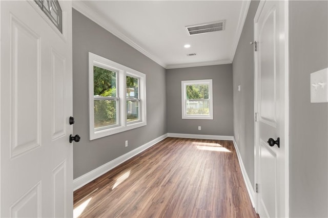 empty room featuring crown molding and wood-type flooring