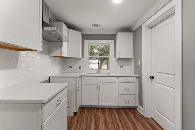 kitchen with dark hardwood / wood-style flooring, white cabinetry, sink, and wall chimney range hood