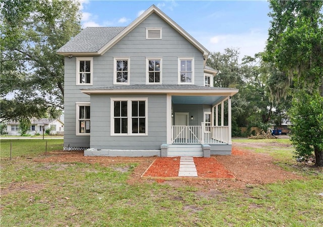 rear view of property featuring covered porch and a yard