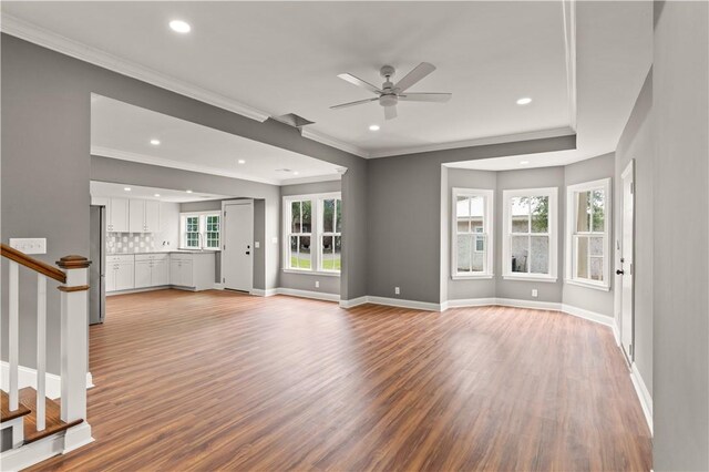 unfurnished living room featuring hardwood / wood-style floors, plenty of natural light, ornamental molding, and ceiling fan