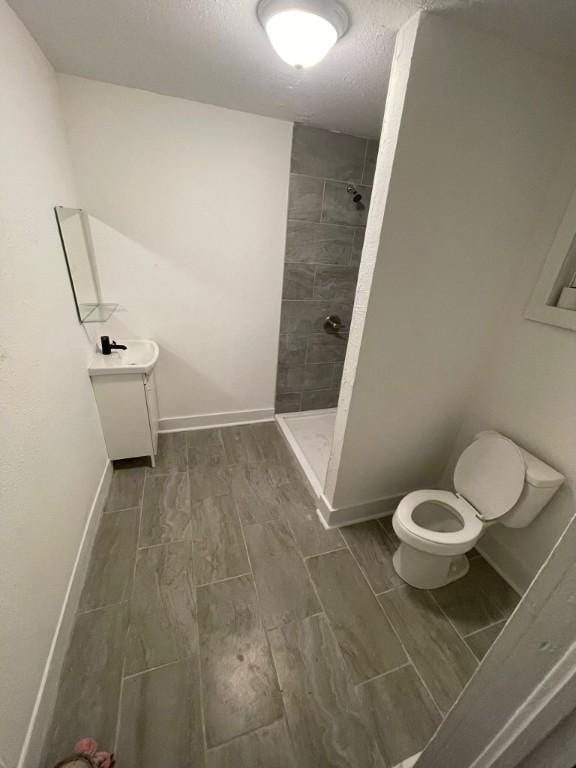 322 Archer St, Waycross, GA 31501 - bathroom with wood tiled floor, a tile shower, and toilet