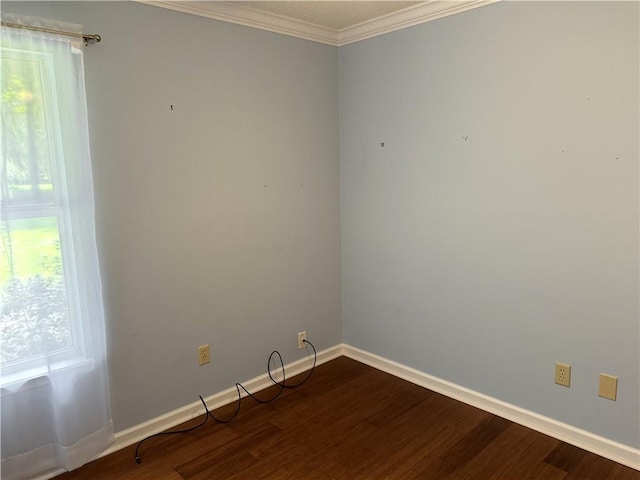 unfurnished room featuring dark wood-type flooring, crown molding, and baseboards