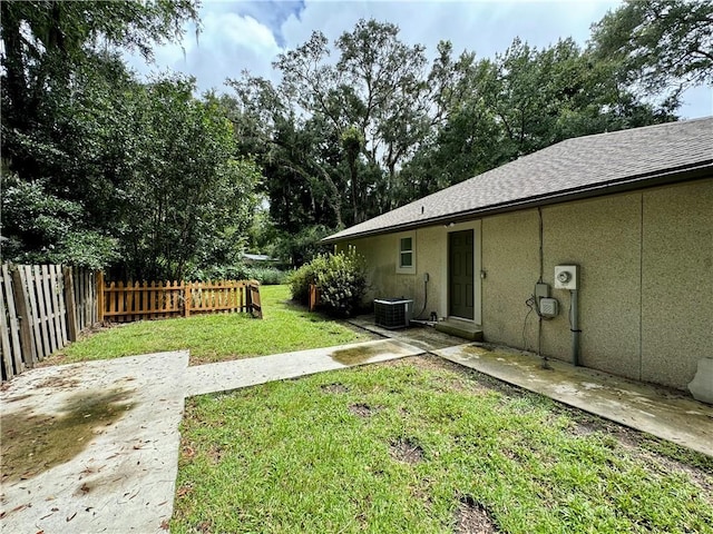 view of yard with central AC unit, a patio area, and fence