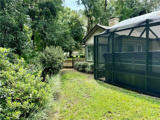 view of yard featuring a lanai and fence