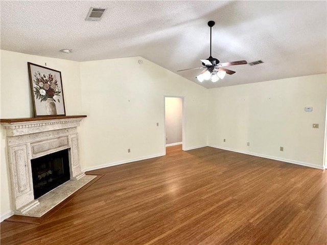 unfurnished living room with a premium fireplace, wood finished floors, and visible vents