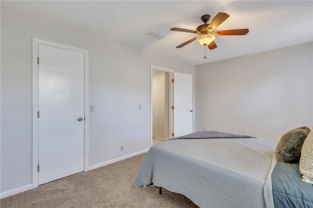 carpeted bedroom with visible vents, baseboards, and ceiling fan