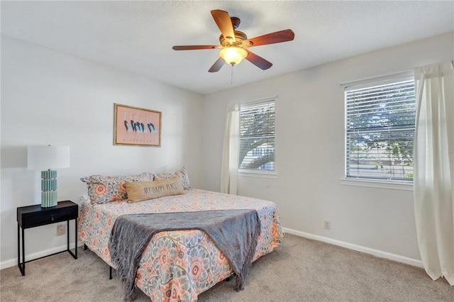 bedroom featuring multiple windows, carpet flooring, a ceiling fan, and baseboards